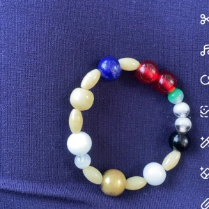 Färgglatt Frälsarkrans-armband - Säljer ett Frälsarkrans-armband med pärlor i olika färger som rött, blått, grönt, svart, vitt, guld och beige. Pärlorna är runda och ovala och sitter på en elastisk tråd. Perfekt accessoar för dig som gillar unika och symboliska smycken. Pärlorna är av glas. Aldrig använt! Pris går att diskutera