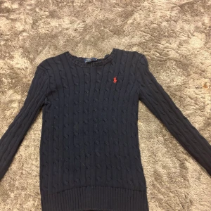 Mörkblå kabelstickad tröja Polo Ralph Lauren - Kabelstickad tröja från polo Ralph lauren använd ett antal gånger men fortfarande i bra skick! 