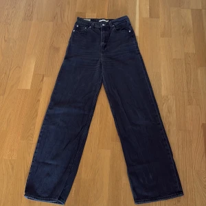 Levi's High Loose svarta jeans, stl 26 - Säljer ett par svarta Levi's High Loose jeans i storlek 26. Jeansen har hög midja och en loose, rak passform med breda ben. Klassisk femficksmodell i kraftigt denimtyg med snygga detaljer och Levi's-logga på bakfickan. Fint skick! W26 L33