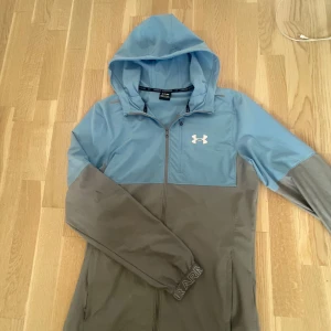 Under armour windbreaker - Under armour windbreaker köpt på Jd för 1400kr mycket bra skick stl s priset är prutbart inga fläckar eller något. Baksidan är samma färg.
