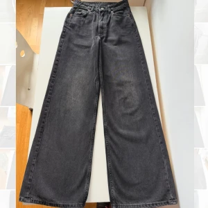 Svarta vida jeans  - Säljer ett par svarta vida urtvättade jeans från H&M Divided i storlek 34. Jeansen är högmidjade.  Säljer pga dem blev för små i midjan.