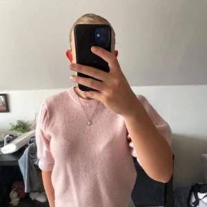 Ljusrosa stickad tröja Gina Tricot - Superfin ljusrosa stickad tröja från Gina Tricot med puffiga ärmar och ribbade muddar. Tröjan har en rund halsringning och är perfekt för dig som gillar en söt och enkel stil. Passar både till jeans och kjol.