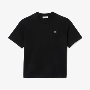 Svart t-shirt från Lacoste - En svart t-shirt från Lacoste med klassisk passform och rund hals. T-shirten har korta ärmar och den ikoniska gröna krokodilloggan broderad på bröstet. Tillverkad i mjuk bomull som känns skön mot huden. Perfekt till jeans eller shorts.Om du behöver en annan storlek kan du kolla min profil.  