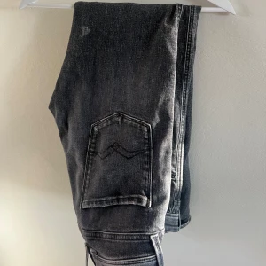 Replay Anbass svarta jeans - Snygga Replay Anbass jeans i svart tvättad denim med slitningar. Storlek W31 L32