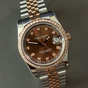 Seiko Datejust brun/silver/guld klocka - Snygg Seiko Datejust med brun urtavla, guldiga index med stenar och tvåfärgad länk i silver och guld. Boetten är dekorerad med glittrande stenar runt ringen och har datumfönster vid kl 3. Klassisk och lyxig design som sticker ut.