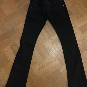 Svarta bootcut jeans - Snygga svarta jeans med bootcut passform och klassiska fem fickor. Jeansen har en stilren look och är perfekta för dig som gillar en tidlös vibe. Materialet är mjukt och stretchigt för extra komfort. Passar till allt och är ett måste i garderoben.