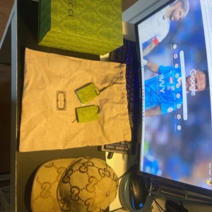 Gucci keps med GG-mönster i beige, pris kan diskuteras - Säljer en snygg Gucci keps i beige med det klassiska GG-monogrammet över hela kepsen. Kepsen har justerbar rem baktill och är tillverkad i bomullscanvas med detaljer i brunt. Perfekt för dig som vill sticka ut med en lyxig accessoar.