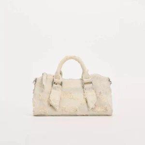 väska -  beige handväska i jeansmaterial med slitna detaljer och silverfärgade metalldelar. från zara förra året den e knappt använd. har dessutom ett långt axelband. Väskan har två handtag och dragkedja upptill. 
