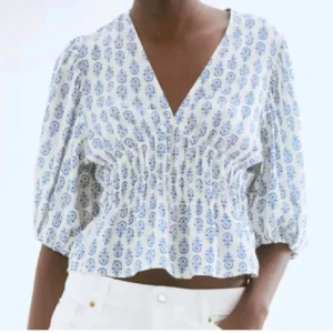 Vit och blå blus med v-ringning - Superfin blus/topp från hm som är helt slutsåld och väldigt eftertraktad. Den är aldrig använd!!