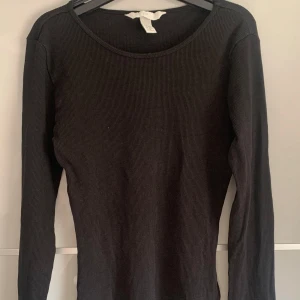 Svart ribbad topp - En svart, ribbad långärmad topp från H&M i storlek XS. Använd få talet ggr men har inga större tecken på användning. Kontakta för frågor eller innan köp!!!