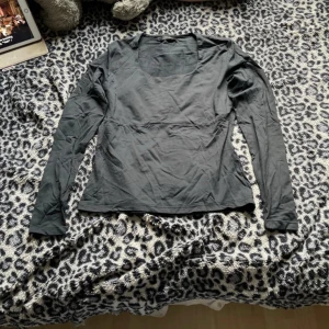 Svart långärmad topp  - En basic svart långärmad topp med rundad halsringning. Perfekt att styla med jeans eller kjol. Enkel och stilren design som funkar till många olika looks.