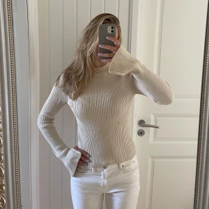 Beige ribbad stickad tröja - Säljer en beige ribbad stickad tröja med lång ärm och lätt utsvängda ärmslut. Perfekt nu inför vintern! Skriv vid fler bilder eller frågor 💙