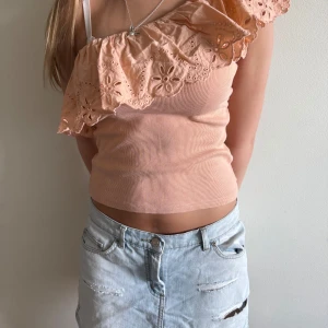 Persikofärgad omlott tubtopp med volang - Superfin persikofärgad tubtopp med bred volang. Säljer för att den inte kommer till andvändning. Hör av dig för fler frågor/bilder 💕