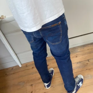 Nudie jeans Grim Tim  - Säljer nu dessa asfeta nudie jeans i modell Grim Tim! Storlek W29 L32 | Skick 7/10 | Nypris 1500-2000kr | Mitt pris 449kr | Hör av dig vid fler frågor eller funderingar! De har en liten lagning i skrevet men den är gjord av Nudie själva så den syns inte och är välgjord.