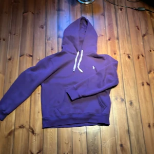 Lila hoodie från Polo Ralph Lauren - Säljer en lila hoodie från Polo Ralph Lauren med vit snörning i huvan och klassisk broderad logga på bröstet. Tröjan har känguruficka, ribbade muddar och är i mjuk bomull. Perfekt för chill dagar eller när du vill ha en clean streetstyle. Storlek S kom för frågor och pruta för en snabb affär 