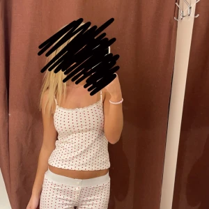 Vit linnetopp med röda hjärtan - Supersöt vit linnetopp med tunna axelband och små röda hjärtan över hela tyget med tillhörande shorts! Perfekt pyjamas! Använd 1 gång då det är för litet❣️Du köper pyjamas settet ihop