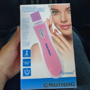 Nagel Elfil  - Elektriskt nagelfil i rosa och vitt med ergonomisk design. Setet innehåller olika sliphuvuden för buffing och filling i lila och grönt. Perfekt för att fixa naglarna hemma med enkel on/off-knapp.
