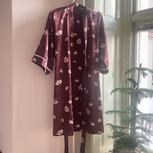 Blommig kimono/morgonrock - Morgonrock i satin med blommigt mönster 🌸Jättefint fall, med knytband i midjan 💕 Passar nog flera storlekar eftersom den går att dra in i midjan, ca S-L skulle jag säga ❤️observera att fållen börjat gå upp i nederkant (sista bilden) 🫶🏻