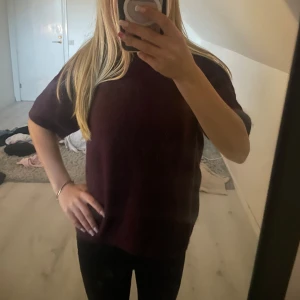 Vinröd stickad tröja med kort ärm - Säljer en mörklila kortärmad tröja från Gina. 