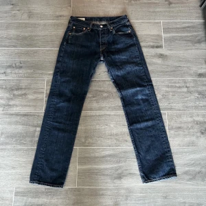 Levi's 501 jeans - Pris kan diskuteras och mer info kan du få, det är bara att fråga.                                                     Klassiska Levi's 501 jeans i en mörkblå tvätt. Dessa jeans har en rak passform och är tillverkade i slitstarkt denim. Perfekta för en tidlös stil.