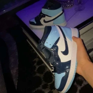 Nike Air Jordan Blue chill, i blå och vit - Snygga Nike Air Jordans i en fräsch kombination av ljusblått, mörkblått och vitt. Skorna har den klassiska Nike-loggan på sidan och snörning framtill. Perfekta för att ge din outfit en sportig touch.