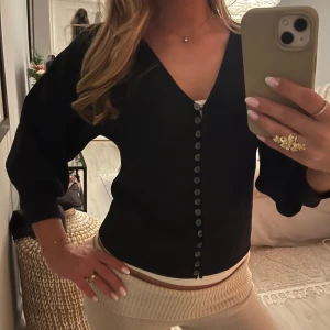 Svart kofta med knappar - Snygg svart kofta med knappar framtill. Koftan har en v-ringad design och trekvartsärmar. Köp nu!💖