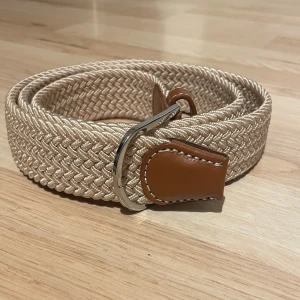 Beige flätat bälte - Hej, säljer ett stilrent beige flätat bälte som passar med det mesta. 110 cm. Kan gå ner i pris vid snabb affär!