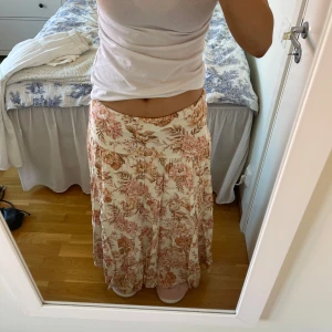 Blommig långkjol  - Säljer en vacker långkjol med blommigt mönster i beige och rosa. Kjolen har en lös passform och är perfekt för varma dagar. Den är tillverkad i ett lätt och luftigt material som ger en skön känsla. På bilderna har jag vikt ner kjolen så den blir extra lågmidjad. Från Forever New och är köpt för ungefär 600kr säljer nu för 200kr💕de går at pruta! Storlek 34 men passar mer som S!