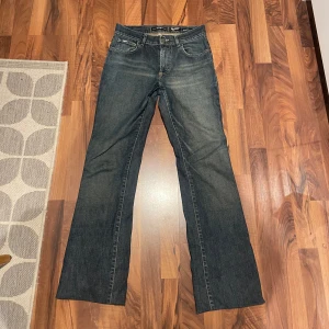 Blå bootcut jeans från GAS - Säljer ett par klassiska blå bootcut jeans från GAS. De har en snygg tvätt och femficksdesign med märkets logga på baksidan. Perfekta för en avslappnad stil. Lågmidjade och UPPSYDDA