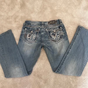 Blå jeans från Miss Me - Snygga blå jeans från Miss Me med broderade detaljer på bakfickorna. De är bootcut och är lågmidjade. Passar perfekt på mig som är 163🤗. Andvända fåtal gånger jätte bra sick!