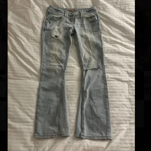 Lågmidjade utsvängda jeans - Ljusa lågmidjade utsvängda jeans med hål. I mycket bra skick, de är utsydda men det syns knapp. Måtten finns bland bilderna, pris kan diskuteras❣️