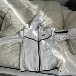 Vit Nike tech - Nike tech köpt för ungefär ett år sedan. Nypris 1200kr. Hoodien har en väldigt liten fläck som knappt är synlig. Hör av er om ni vill diskutera pris.