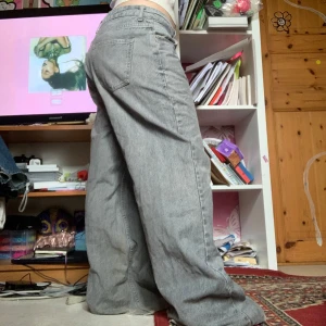 Grå wide jeans från Zara - Säljer ett par grå wide jeans från Zara, modell 'The Boogie Pant'. De har en avslappnad passform med hög midja och klassisk femficksdesign. Perfekta för en trendig och bekväm stil.