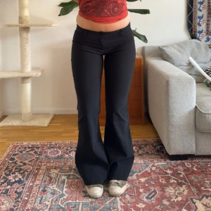 Lågmidjede utsvängda kostymbyxor  - Så snygga utsvängda, lågmidjade vintage kostymbyxor. Midjemåttet är ca 37cm rakt över och innerbenslängden är ca 81cm.