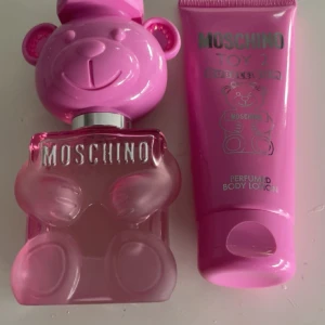 Moschino Toy 2 Bubblegum Parfym - Säljer en söt och lekfull Moschino Toy 2 Bubblegum parfym i en rosa flaska formad som en nallebjörn. Flaskan har en glansig finish och är perfekt för den som älskar unika och roliga designparfymer. Den kommer med en matchande body lotion i samma doft.