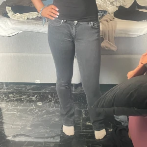 Grå jeans med normal passform - Snygga grå jeans med en klassisk femficksdesign och normal passform. De har en stilren look med en knapp och dragkedja framtill. Perfekta för en avslappnad stil.