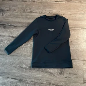 Mörkgrön tröja från Jack & Jones - Säljer en stilren mörkgrön tröja från Jack & Jones. Tröjan har en enkel design med rund hals och långa ärmar. Perfekt för lite mer chill look.