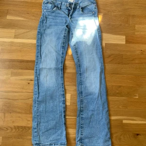 Blå jeans  - Säljer ett par klassiska blå jeans från Gina Tricot. De har en normal passform med dragkedja och knapp framtill. Jeansen har fem fickor och en snygg tvättad look. Perfekta för en avslappnad stil.