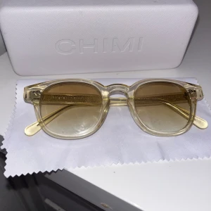 Gula solglasögon från Chimi 01 - Snygga gula solglasögon från Chimi med transparent båge och tonade glas. Perfekta för soliga dagar och ger en cool retro-look. Kommer med ett praktiskt fodral för säker förvaring.