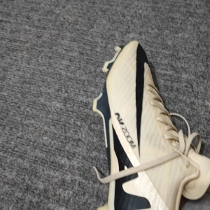  fotbollsskor från Nike - Snygga  fotbollsskor från Nike med svarta detaljer och snörning. Skorna har en rund tå och är designade för optimal prestanda på planen. Perfekta för fotbollsspelare som vill ha stil och funktionalitet.