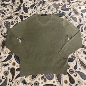 Grön tröja från Polo Ralph Lauren - Säljer en stilren grön tröja från Polo Ralph Lauren med v-ring. Inte använd mycket å funkar perfekt! 9/10 skick! Färg: mörkgrön/khaki, nypris: 1500kr, här endast 399kr. Kontakta vid minsta intresse!