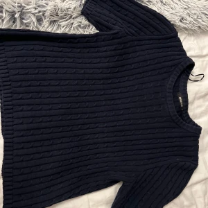 Mörkblå ribbad tröja från Zara - Säljer en stilren mörkblå ribbad tröja från Zara. Tröjan har korta ärmar och en rund halsringning, perfekt för en avslappnad look. Passar bra till både jeans och kjol. Perfekt för vår och sommar!