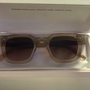 CHIMI 04 - Snygga solglasögon från Chimi i en stilren beige färg. De har en fyrkantig form och ger en modern look. Perfekta för soliga dagar och kommer i ett praktiskt fodral. Glasögonen är i modell 04 och färg ECRU. Samrsamt använda, priset går att diskutera😀