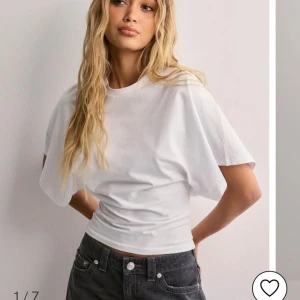 Vit kortärmad topp - Säljer en stilren vit kortärmad topp med en lös passform. Perfekt för en avslappnad look. Toppen är tillverkad i ett mjukt material som ger en skön känsla mot huden. Använd en gång, nypris 299kr! 💗 Skriv för frågor