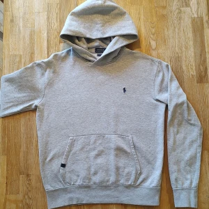 Grå hoodie från Polo Ralph Lauren - Säljer denna riktigt snygga hoodien från Ralph Lauren. Stl M men passar kanske bättre som en S. Superskick, inga defekter, endast snöret till huvan som saknas. Fråga mig gärna om mått etc ☀️