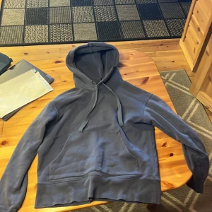 Grå hoodie från Acne Studios - Säljer en stilren grå hoodie från Acne Studios med en klassisk känguruficka och justerbar huva. Tröjan har en diskret logotyp på bröstet, passar folk mellan 160-170, skick 8/10, ny pris på såna här hoodies är runt 1700-2200kr, hör av er vid frågor och priset är inte hugget i stenen!!