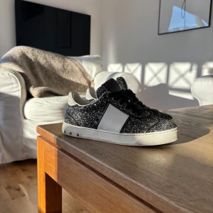 Svarta glittriga sneakers - Säljer nu mina fina valentino garavani skor som är i fint skick, inte använda mycket och är i storlek 36,5. Ända nackdelen är att de saknas två nitar på höger fot, då de knappt syns, pris går att diskuteras så hör av er! 