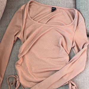 Rosa topp💋‼️❣️ - Säljer en rosa ribbad topp från  med långa ärmar och knytning i sidan. Toppen har dessutom en rund halsringning💋💌🤩💝