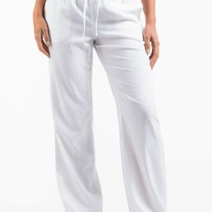 Vita linnebyxor - Snygga och bekväma vita linnebyxor med dragsko i midjan. Perfekta för en avslappnad stil. Byxorna har en loose passform och är tillverkade i ett lätt och luftigt material. Storlek S/tall 