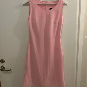 Rosa klänning från Randiga Rutan - Säljer en söt rosa klänning från Randiga Rutan. Klänningen är ärmlös och har en enkel, elegant design med rund halsringning. Perfekt för sommaren 💕